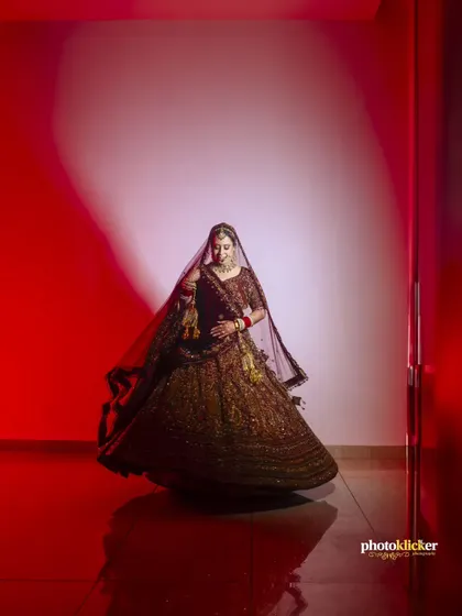 A dynamic shot of the bride twirling in her lehenga, captured with a dramatic red spotlight to create a sense of movement and elegance.