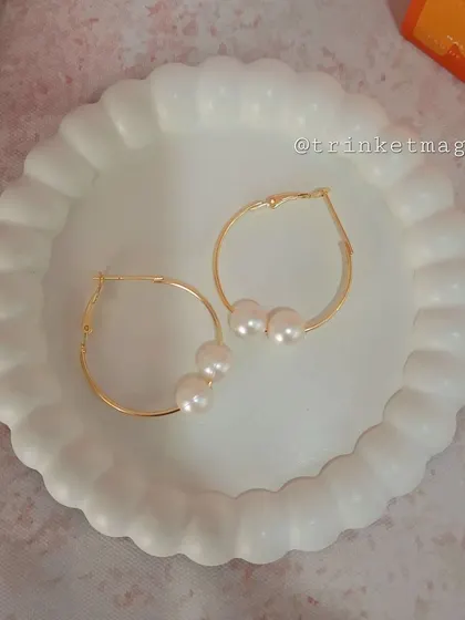 Classic and elegant, these simple gold hoop earrings are adorned with three delicate pearls. They are a timeless accessory for any occasion.