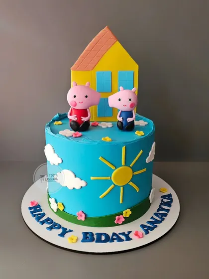 A classic Peppa Pig and George cake for Anayka's birthday. This bright blue cake shows the famous duo outside their yellow house on a sunny day.