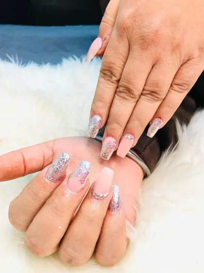 A close-up view of the glitter and rhinestone details on these coffin nails.