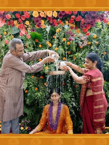 Another shot of the Haldi ritual, capturing the joy and tradition of the moment against the custom-designed floral wall.