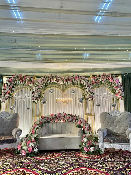 The full engagement stage setup with a central love seat and two ornate throne chairs for the couple and their family.