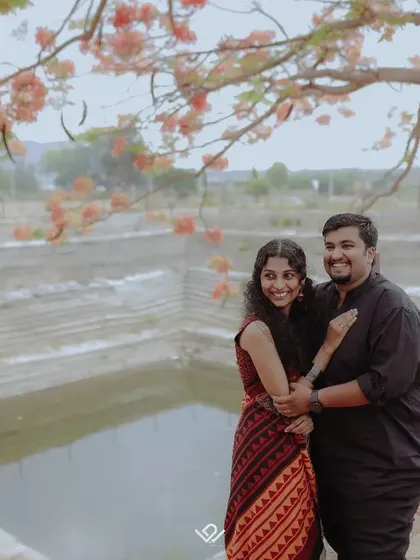 A happy couple embraces by a traditional Indian stepwell, surrounded by nature.