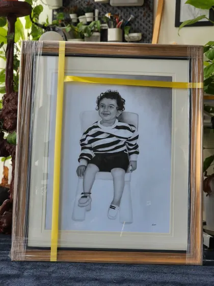 The finished child's portrait, wrapped and framed, ready for its new home. The wooden frame adds a warm, classic touch.