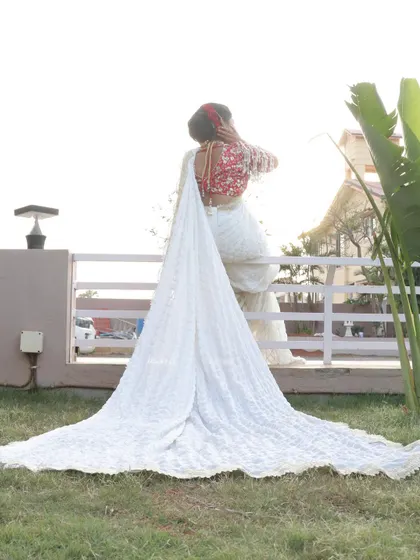 The dramatic trail of a custom bridal saree creates a breathtaking silhouette. This shot highlights how the right styling, paired with perfect makeup, can create unforgettable wedding photos.