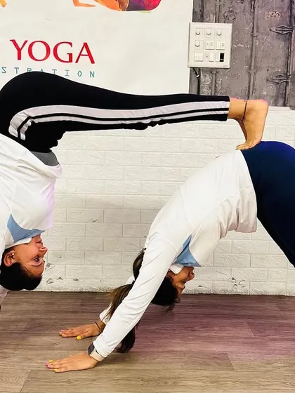 A creative and challenging partner pose, forming a double Downward-Facing Dog. This not only builds strength and balance but also requires great communication and teamwork.