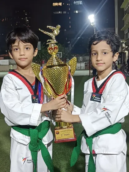 Two young champions holding their first-place trophy. Teamwork and partnership are essential in our training.