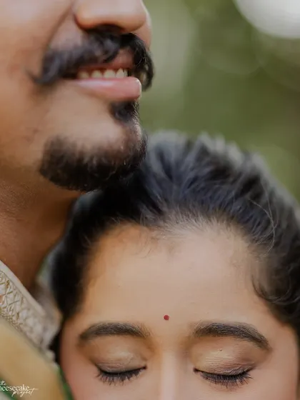 An artistic, cropped shot focusing on the bride's serene expression as she rests her head on her husband.