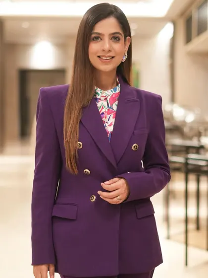 A three-quarter shot in the purple suit, showing how I pair professional attire with a warm and approachable expression.
