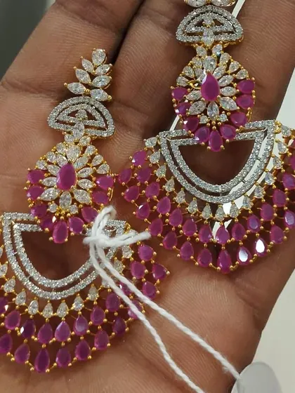 Stunning chandbali-style earrings made with ruby-coloured stones and American diamonds. The design is very full and festive, perfect for weddings.