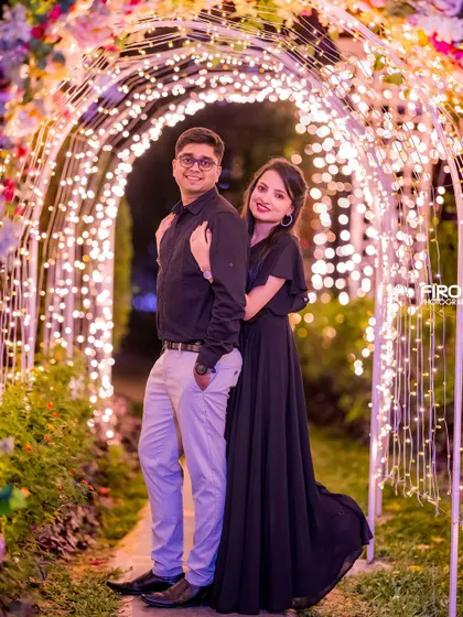 A classic pose inside a beautiful archway of fairy lights. The warm glow surrounds the couple, creating a romantic and enchanting portrait.