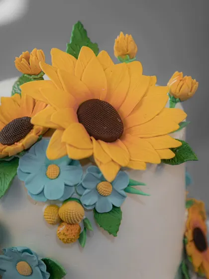 Another angle of the beautiful sunflower cake, showing the arrangement of yellow and blue flowers.