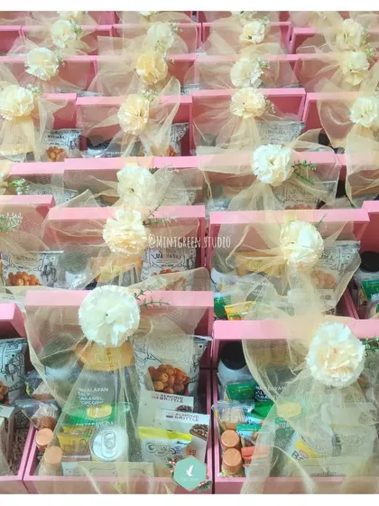 A large batch of wedding room hampers, elegantly decorated with net and artificial flowers. This showcases my ability to handle large-scale event gifting with a consistent, beautiful aesthetic.