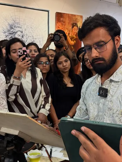 Using a reference on my tablet while demonstrating watercolor techniques to an engaged audience in New Delhi.