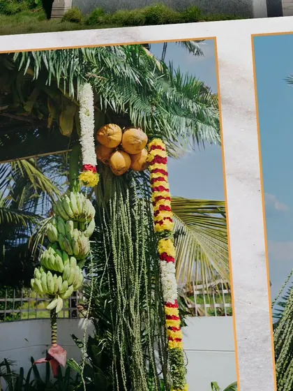 A close-up of traditional decor elements, including banana stalks and coconuts wrapped in flower garlands. These details are essential for an authentic South Indian wedding feel.