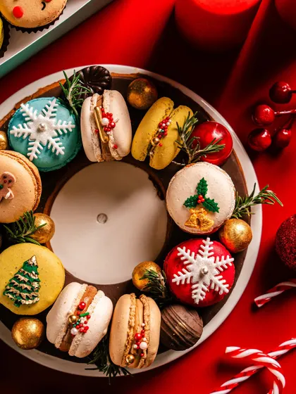 A close-up of the macaron wreath, showcasing the detailed decorations on each macaron, from snowflakes to Christmas trees. It's a testament to the artistry and festive flavor I bring to my holiday collection.