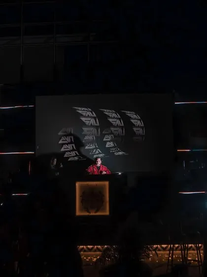 A wide shot showing me on a massive stage at House of Lords, with my logo on the big screen. I'm comfortable playing on any scale.
