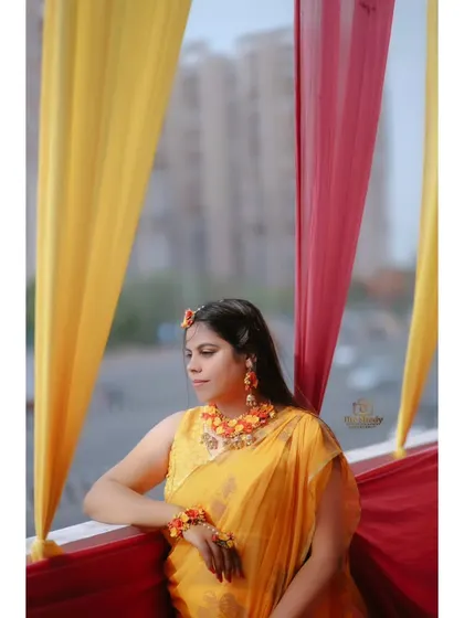 A thoughtful portrait of the bride by the window during her Haldi ceremony. The soft, natural light creates a beautiful, serene mood.
