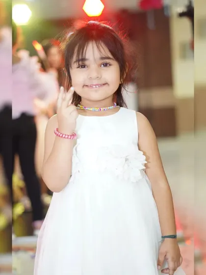 A sweet portrait of a young girl in a white dress at a party. We take beautiful individual photos of the children attending the event.