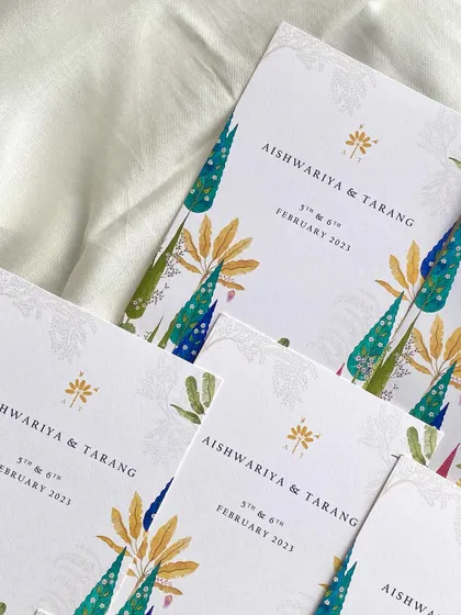 A stack of the illustrated welcome cards for the Champaner wedding. The vibrant and artistic design gives guests a beautiful keepsake of the celebration.