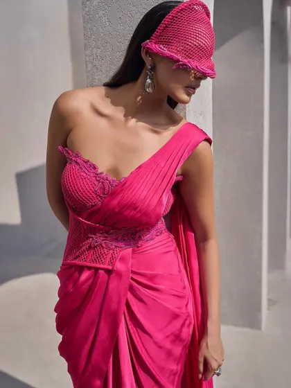 This hot pink corset sari is a statement of power and passion. Drenched in a vivid hue, it is cinched to perfection and draped with boldness.