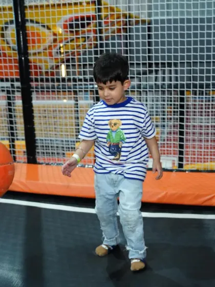 A young boy mid-game in the trampoline zone, focused and having a great time.