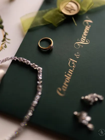 A close-up of the wedding invitation, ring, and earrings, capturing the fine details and personal touches of the day.