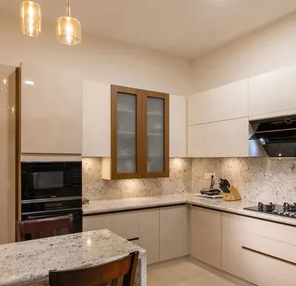 This open kitchen features a breakfast counter that seamlessly connects it to the dining area. The neutral-toned cabinets and Moroccan-inspired backsplash create a warm and social atmosphere.