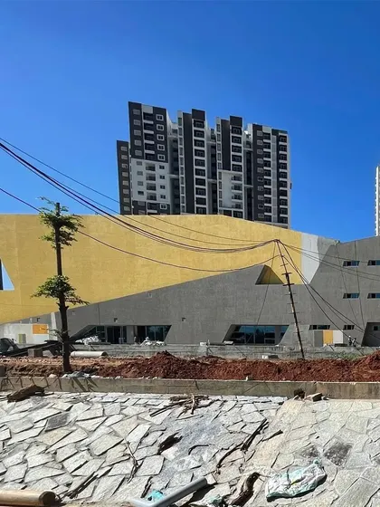 The brigade utopia clubhouse under construction, with its bold yellow facade taking shape against the residential towers.