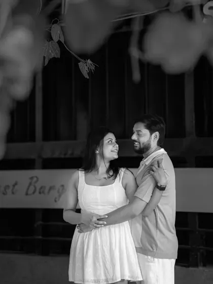 A quiet, intimate moment captured in black and white. This photo focuses on the couple's connection, framed by the subtle details of their urban surroundings.