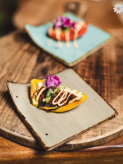 A modern presentation of a classic dish, served on a bed of roasted peppers. The vibrant colours and careful placement of each element demonstrate our commitment to culinary artistry.
