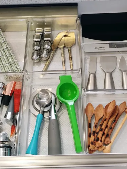 This bar and coffee drawer is perfectly organized with clear acrylic trays. Each tool, from the lemon squeezer to the honey dippers, has its own compartment, making it ready for cocktail hour.