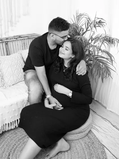An intimate moment from an indoor boho maternity session. A gentle kiss on the forehead in this black and white portrait creates a feeling of warmth and tenderness.