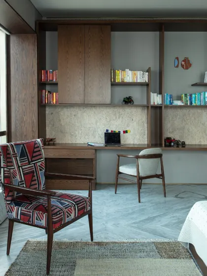 The daughter's bedroom is a dreamy retreat, centered around a custom leather and cane bed. A dedicated study area at the rear is designed for creativity and focus, with ample shelving and a corkboard backsplash.