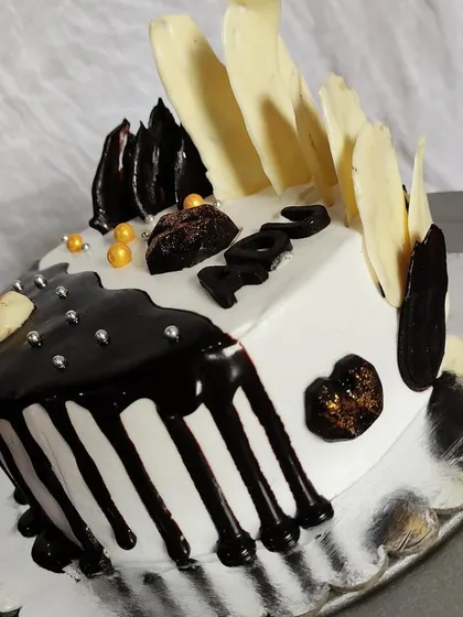 Another view of my black-and-white half-and-half cake. This angle shows the contrast between the dark chocolate drip and the white chocolate shards.