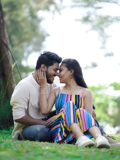 A cute and candid moment sitting on the grass. Their colorful outfits pop against the natural background, and their smiles are full of warmth.