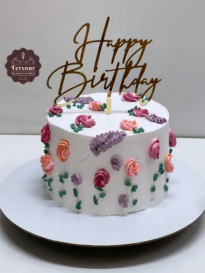 A simple and beautiful birthday cake decorated with hand-piped buttercream flowers. This vanilla truffle cake is a testament to classic cake decorating skills.
