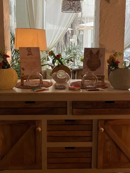 A dedicated station for baby shower games and well wishes, styled with simple floral arrangements to match the rest of the decor.