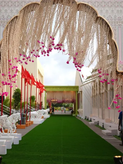 The grand entrance for the baraat, lined with horse statues and leading through arches adorned with floral curtains. We designed this pathway to build anticipation for the spectacular ceremony ahead.