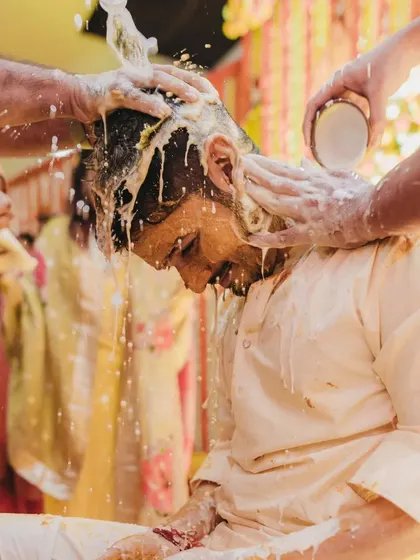 A close up of the groom during the 'doodh haldi' ritual, where he is showered with milk as part of the ceremony.