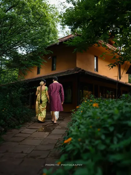 The couple walks away hand-in-hand down a stone path, towards a beautiful rustic home, symbolizing the start of their journey together.