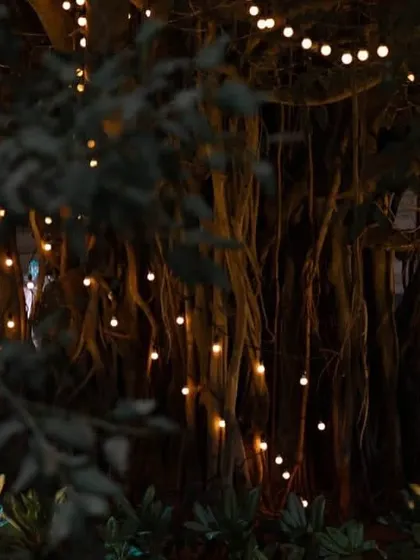 The outdoor lounge area for a reception, illuminated by fairy lights and candles. The elegant white furniture and surrounding greenery created a cozy and romantic space for guests to relax.