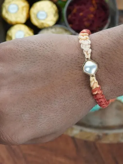 The Kundan Rakhi being worn on the wrist. It's designed to be comfortable and stylish.