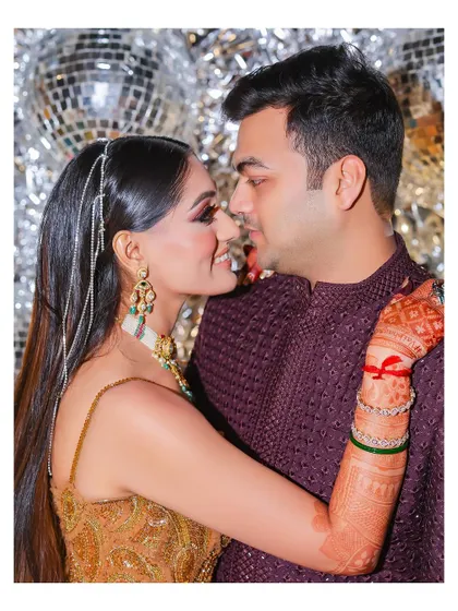 A close-up of the couple sharing a loving gaze. The bride's intricate gown and the groom's classic sherwani are beautifully captured in this tender moment.