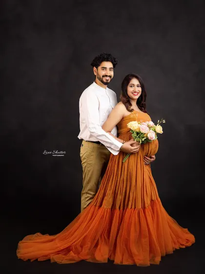 A bright and happy maternity portrait. The mom-to-be holds a bouquet of flowers, adding a fresh and joyful element to this studio session.