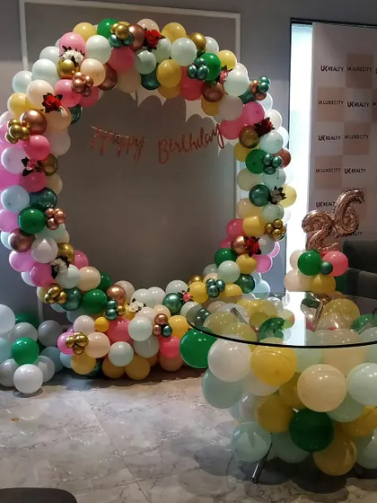 A vibrant multi-colored balloon ring for a 26th birthday, creating a festive photo spot.