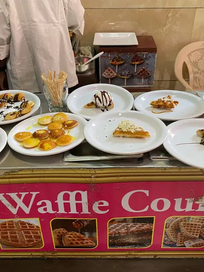 Our live Waffle Counter, offering a variety of toppings like chocolate sauce, ice cream, and nuts.