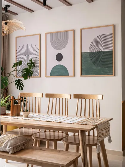 This Japandi-style dining area features a simple wooden table and chairs, complemented by minimalist abstract art in earthy tones. The design is clean, calm, and connected to nature.
