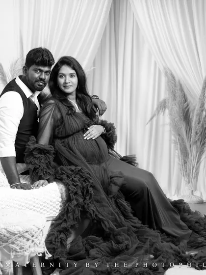 A classic black and white portrait of a couple in a boho studio setting, looking elegant and timeless.