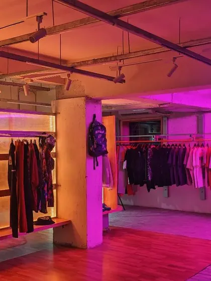 The finished interior bathed in purple and orange light. The design uses lighting to define "street pockets" and "alleyways," creating a sense of discovery as customers navigate the store.